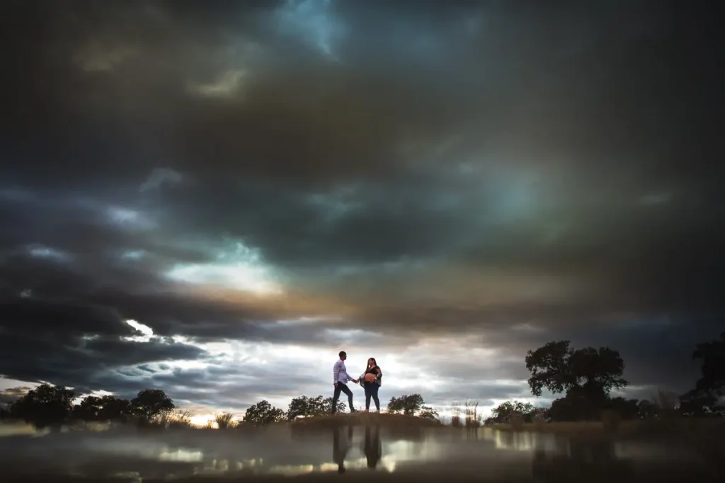 fotografia profesional premama con pareja de la mano paisaje nublado