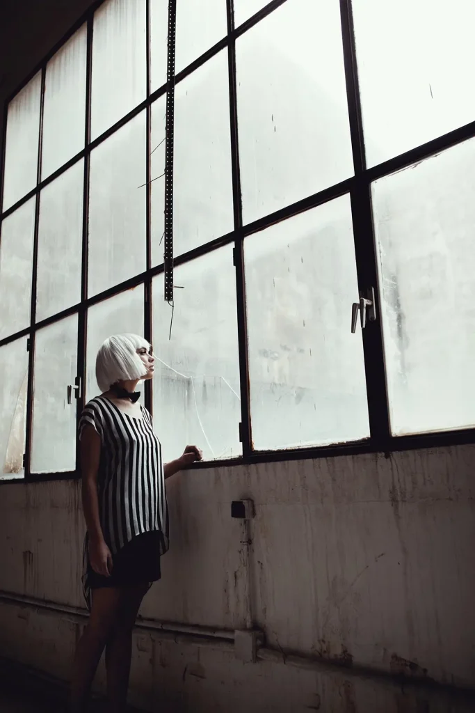 modelo profesional peluca ropa rayas blanca negra industrial mirando ventanas